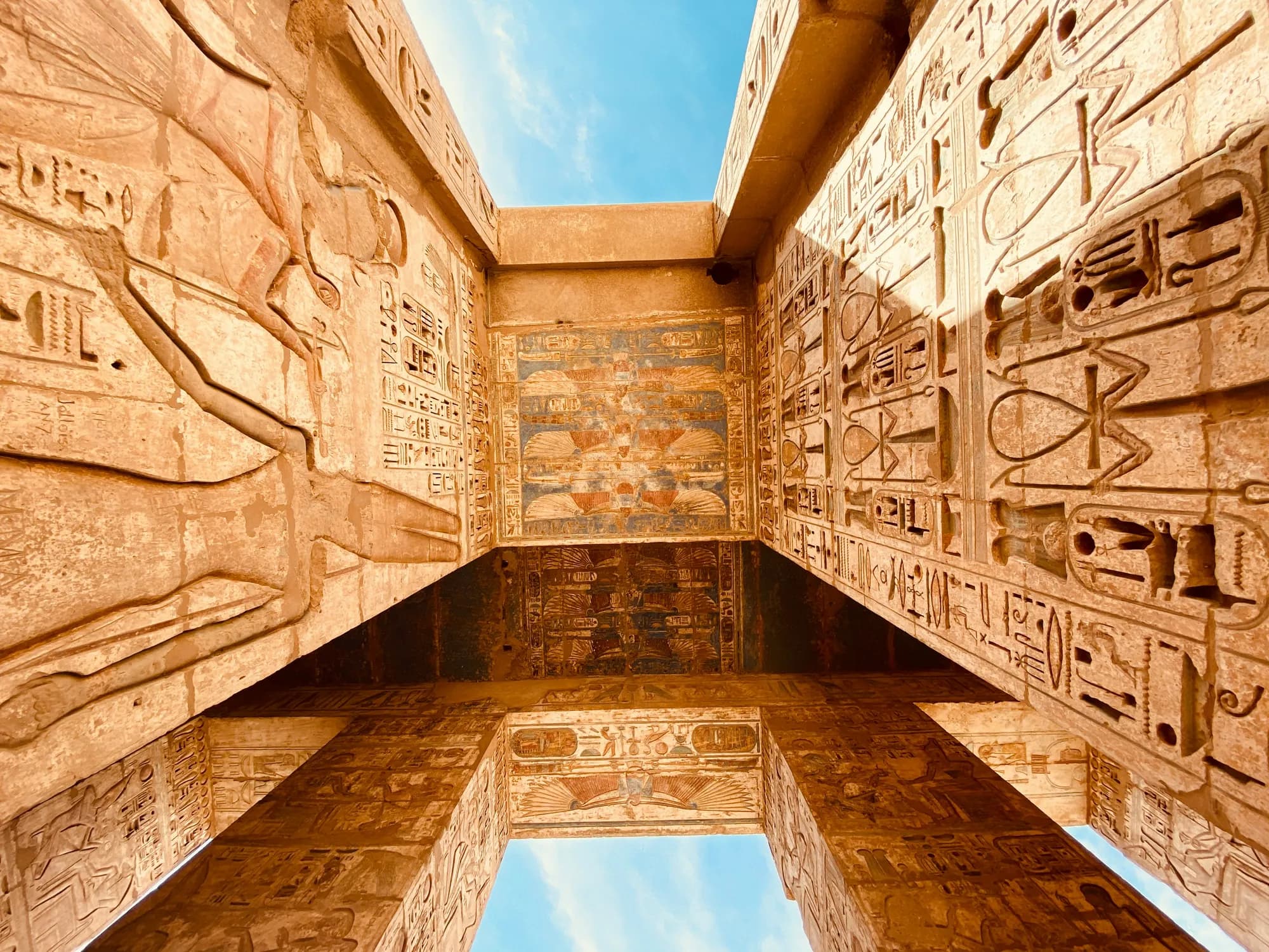 Sunlit hieroglyph-covered columns of an ancient Egyptian temple